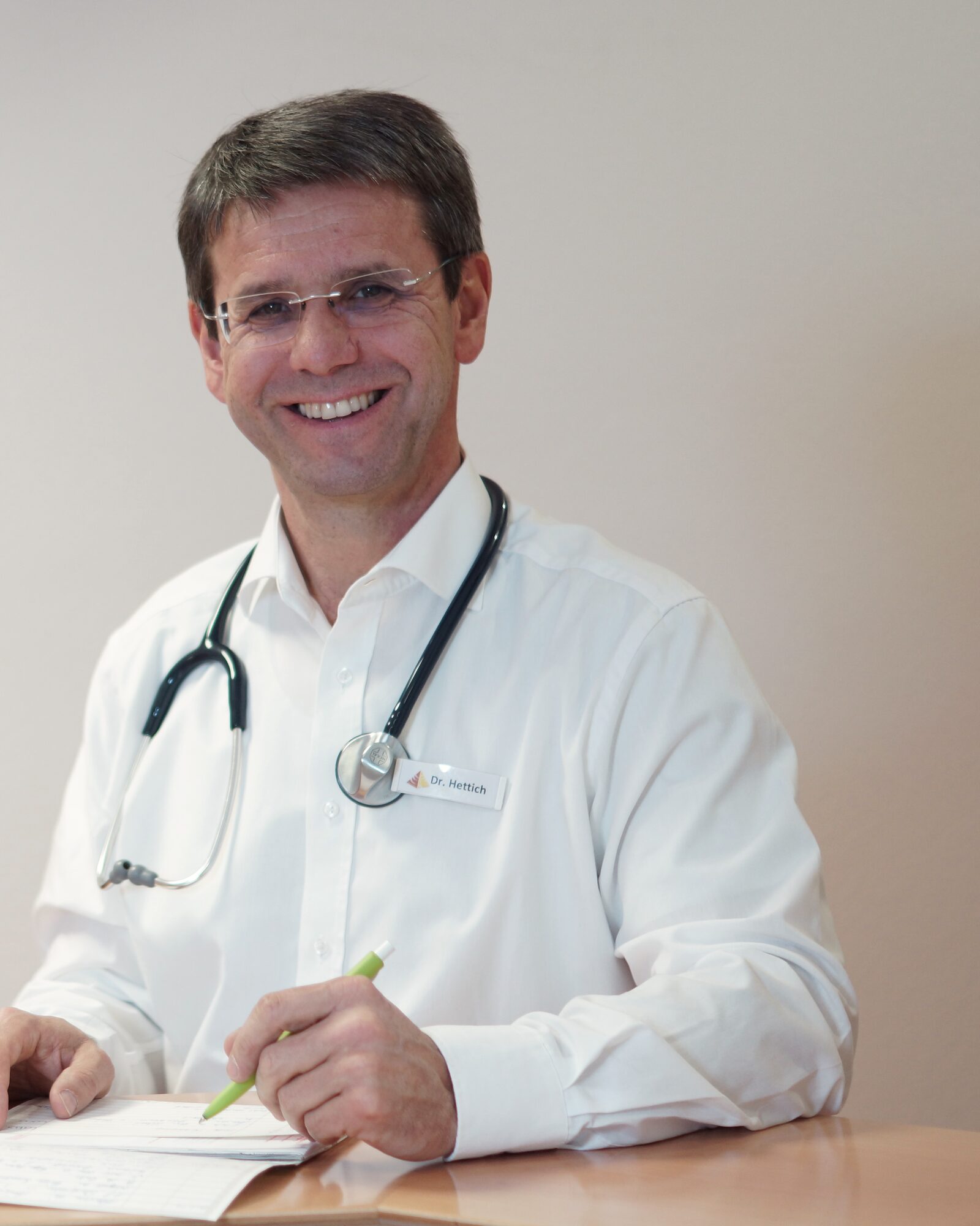 Dr. med. Armin Hettich am Empfangstresen seiner Praxis